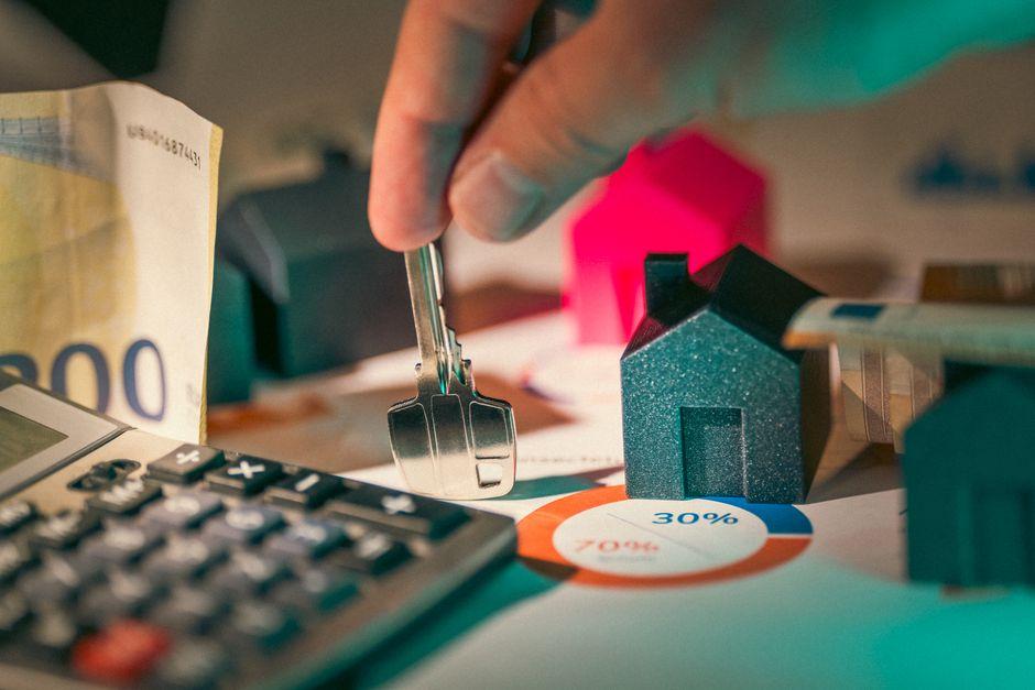 Housing Investment Prices Hand Holding Key to New House Door